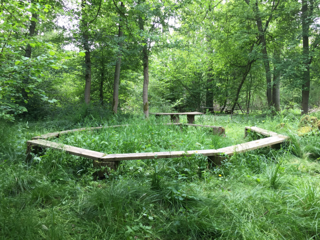 large hexagonal wooden bench in forest